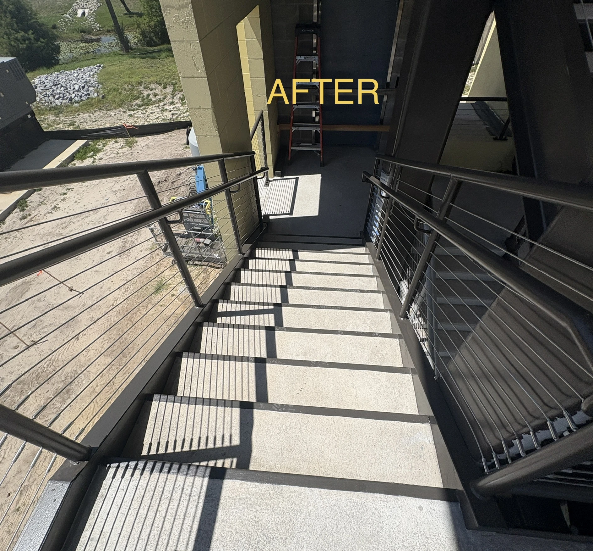 Looking down the commercial staircase showing bronze steel framing and cable rails