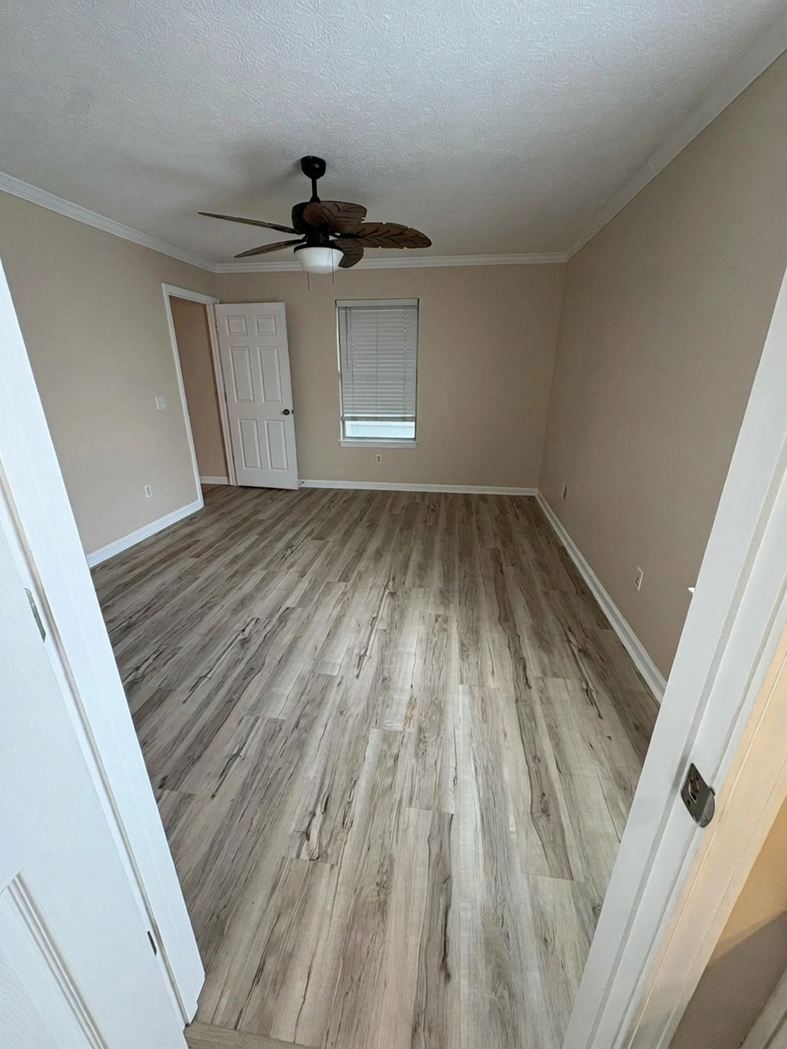 Primary bedroom repainted in cohesive warm coastal beige after painting