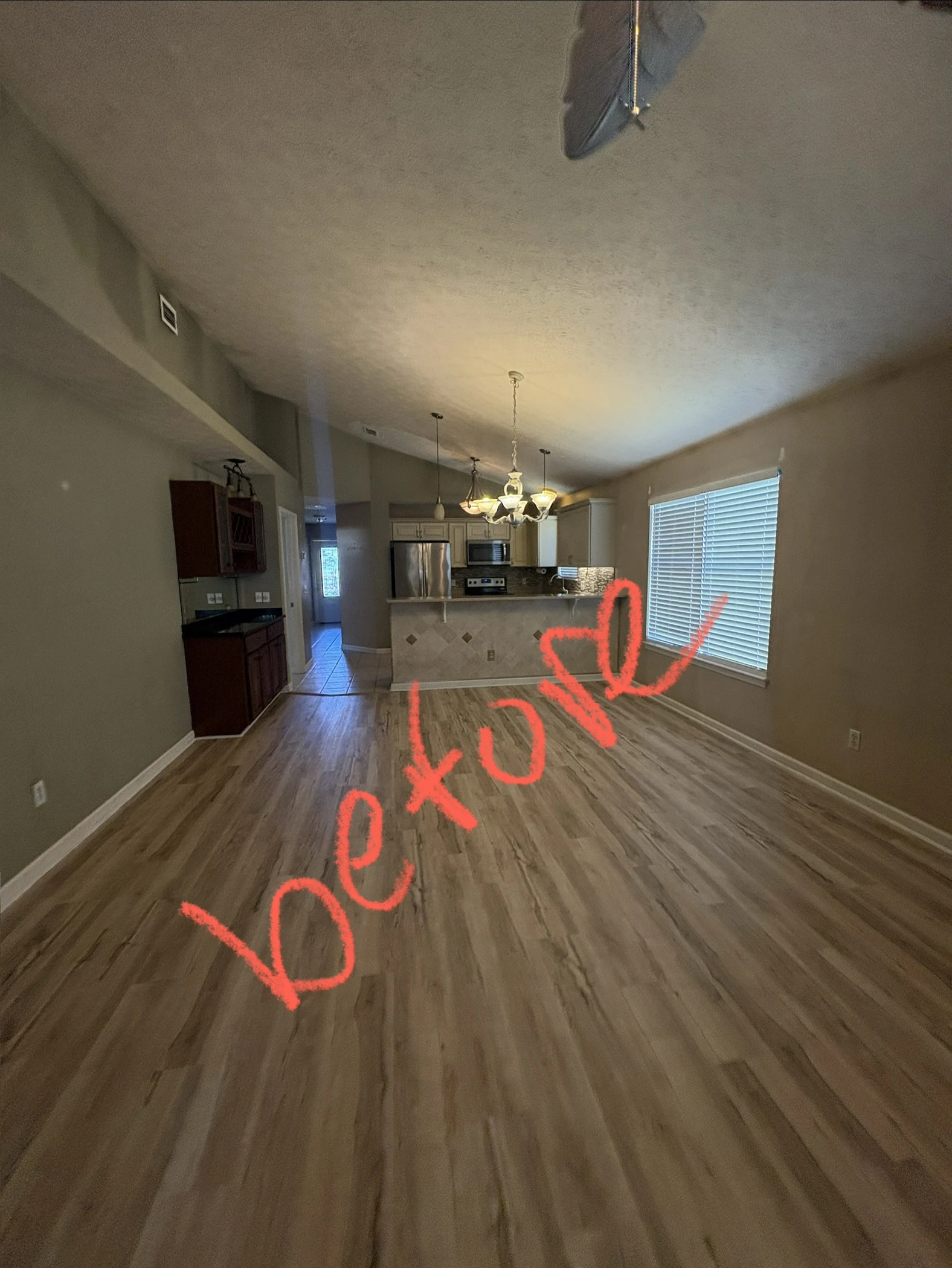 Open-concept living room with split-tone dark walls before painting